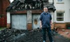 Councillor, Graeme Campbell standing outside his house, which was firebombed this week, causing considerable fire damage, as well as destroying his cars.