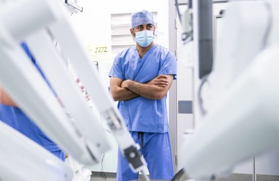 Health Secretary Humza Yousaf watches a surgical robot at work at Glasgow Royal Infirmary.