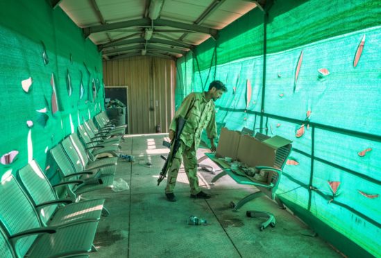 An Afghan army soldier surveys belongings left by the US military inside the Bagram Air Base, some 50 kilometers north of the capital Kabul, Afghanistan.