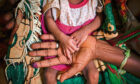 Abeba Gebru holds her baby daughter’s hands