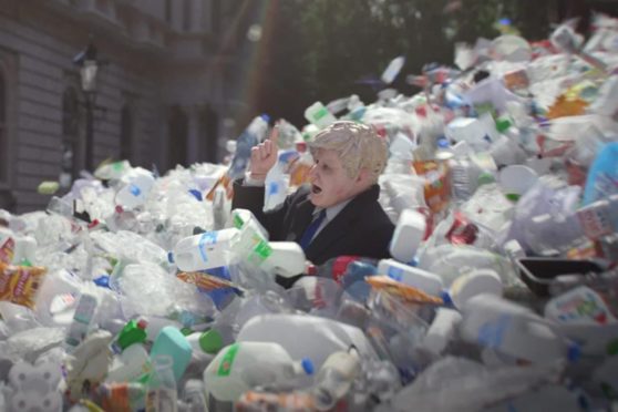 A model of Boris Johnson is swept out of Downing Street in a deluge of plastic waste in a campaign film from Greenpeace