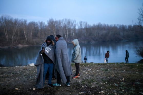 Migrants in Turkey prepare to cross the Evros River in March 2020