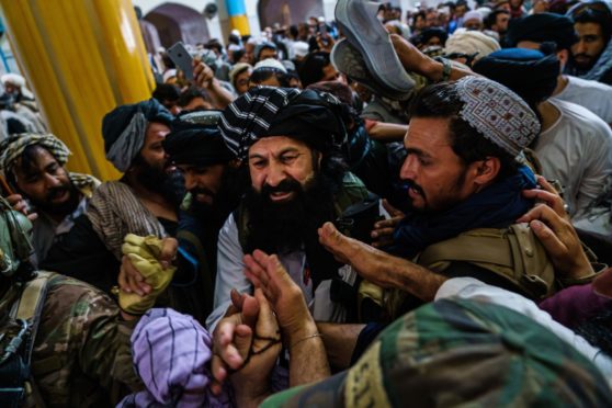 Supporters clamour to greet Khalil al-Rahman Haqqani, a leader of the Taliban-affiliated Haqqani network, who the US says is a terrorist with a $5m bounty on 
his head, after his sermon at the Pul-e-
Khishti Mosque in Kabul last week