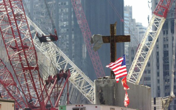 At the World Trade Center disaster site in October 2001 – just weeks after the terror attack – workers use heavy machinery to remove one of the steel beams from the section dubbed Gods House in reference to the many crosses inside