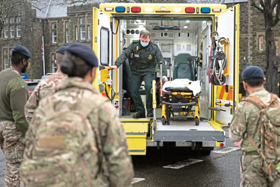 Members of the military practice loading and unloading a stretcher into an ambulance at Maindy Barracks.