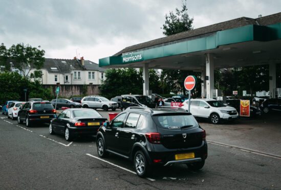 Cars queue at Morrisons petrol station on the south side of Glasgow yesterday as drivers panic-buy