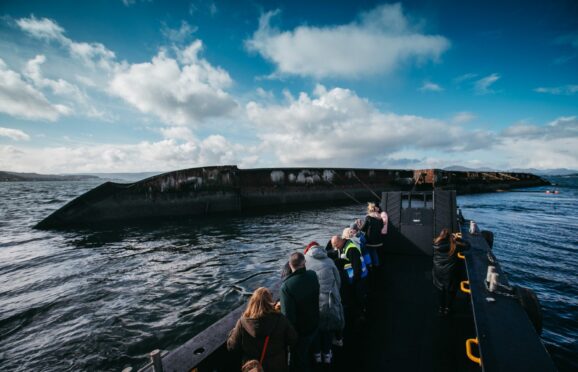 Passengers on board the Tonka view the sugar boat wreck which sank in 1974