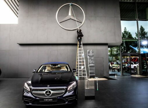 A worker cleans the Mercedes-Benz logo at motor show in Frankfurt, Germany in 2019