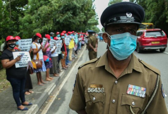 A police officer stands guard as trade union members in Sri Lanka protest near the parliament in Colombo earlier this month