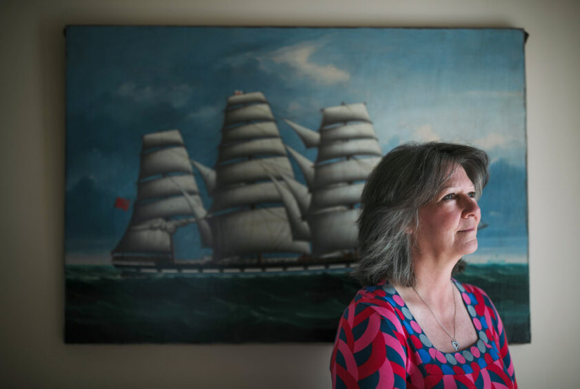 Jackie Hood stands in front of a painting of the Springbank at her home in Helensburgh