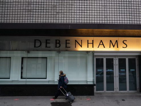 A person walks past closed doors and empty shop windows at the closed down Debenhams store on Oxford Street (Dominic Lipinski/PA)