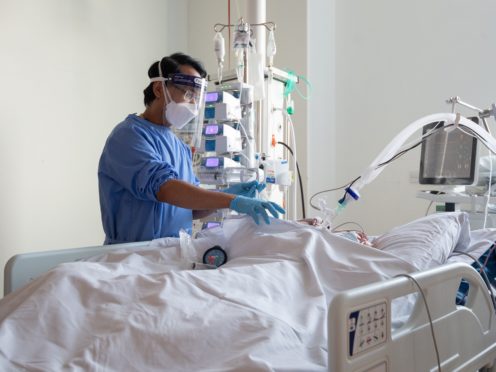 A nurse checks on a patient suffering with Covid-19 in a critical care unit (PA)