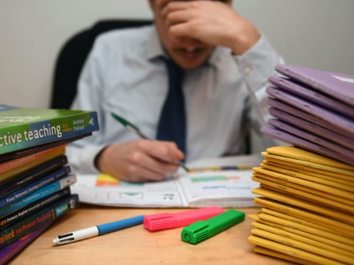 Undated file photo of school teacher looking stressed next to piles of classroom books. Nearly four in five teachers feel their job has adversely affected their mental health during the pandemic, a survey has suggested. Issue date: Saturday April 3, 2021.