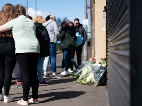 People embrace as flowers and tributes are left at the scene on High Street, Brownhills, near Walsall (Jacob King/PA)