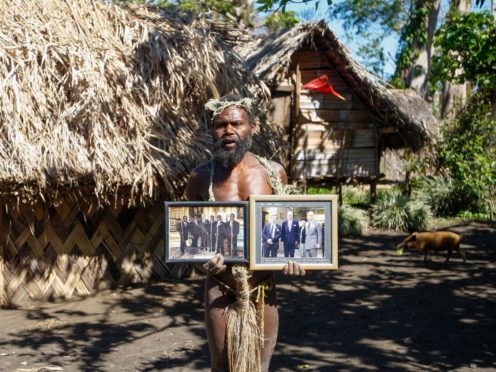 Albi Nagia poses with photographs of Prince Philip in Yakel, Tanna island, Vanuatu in May 31 2015 (AP Photo/Nick Perry, File)