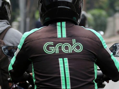 A GrabBike driver rides on his motorbike in Jakarta, Indonesia (Tatan Syuflana/AP)