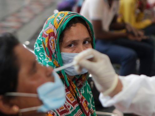 A health worker collects a swab sample at Chhatrapati Shivaji Maharaj Terminus in Mumbai (AP)