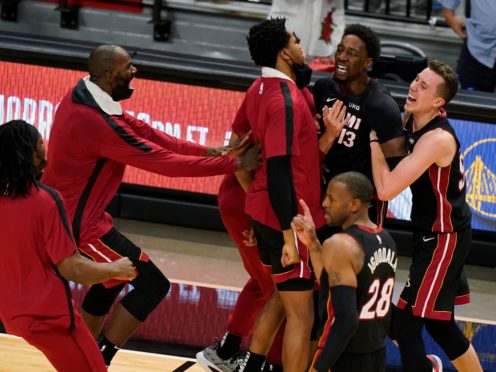 Miami Heat centre Bam Adebayo is mobbed by teammates after he made the winning shot against the Brooklyn Nets (Wilfredo Lee/AP)