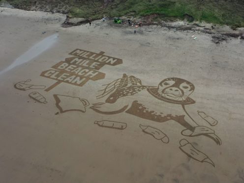 A sand drawing measuring 50 metres has been created on Cayton Bay, Yorkshire, to kick off the million mile beach clean initiative (Surfers Against Sewage/PA)