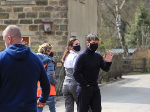 Tom Cruise waves to onlookers as he walks to the set of his latest project (Danny Lawson/PA)