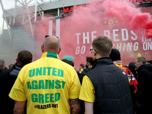A fan wears a shirt with a “United Against Greed” message on it (Barrington Coombs/PA)