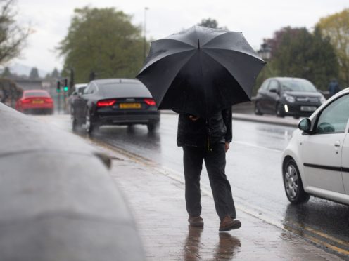 A man holds onto his umbrella in Worcester as wet and windy weather covers much of the region (Jacob King/PA)