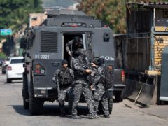 Police get out of an armoured vehicle during an operation against drug traffickers (Silvia Izquierdo/AP)