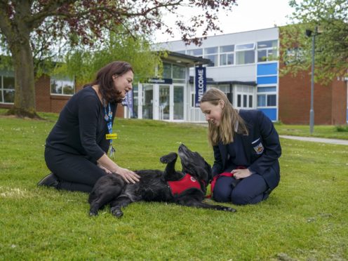 Rebecca Flory, clinical lead in the mental health support team for Gloucestershire Health and Care trust, with Year 10 pupil Lily and the school’s therapy dog Molly at Bournside School in Cheltenham (Steve Parsons/PA)