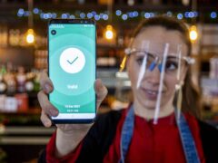 Anabela Monteiro at The Belmont Bar and Bistro in Belfast holds a customer’s scanned digital Health & Social Care Northern Ireland (HSC NI) Covid certificate (Liam McBurney/PA)