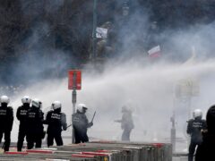 Police set off a water cannon against protesters during a demonstration against Covid-19 measures in Brussels (Geert Vanden Wijngaert/AP)