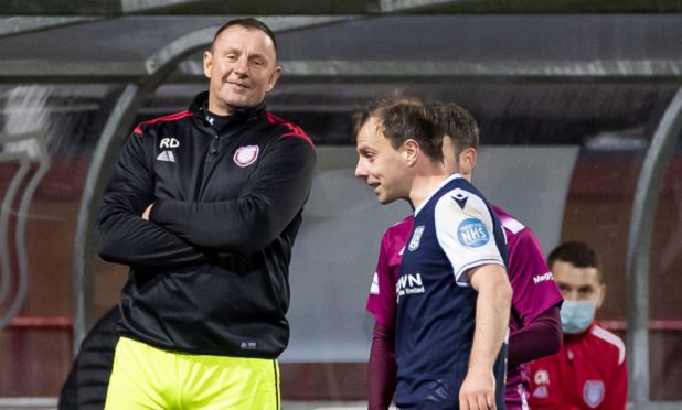 Dundees Paul McGowan shares a joke with Arbroath goalie coach Rab Douglas.