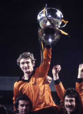 Dundee Utd's Paul Hegarty raises League Cup trophy as team-mates carry him on their shoulders.
