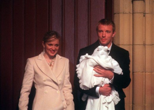 Madonna and British film director Guy Ritchie with their four-month-old baby son Rocco, wrapped in a white christening gown, after the baby was christened at Dornoch Cathedral.