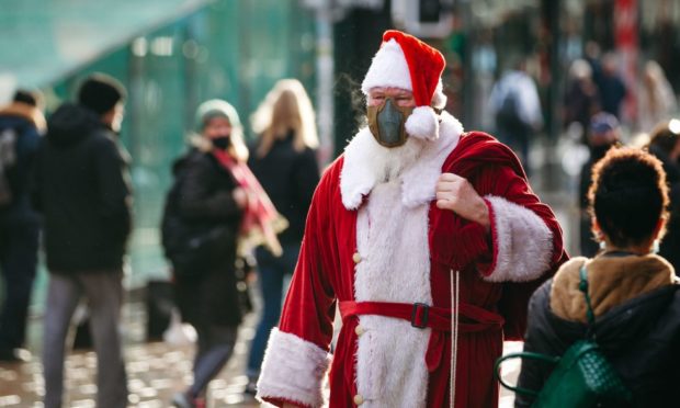 A man dressed as Santa as people do some last minute Christmas shopping in Glasgow.
