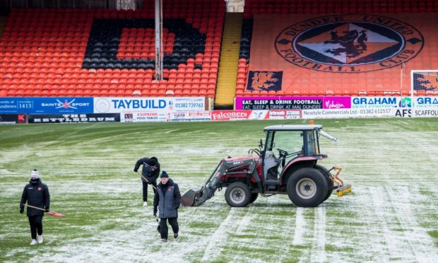 Dundee United staff get to work on frozen pitch.