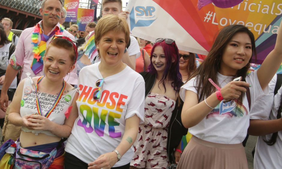 Nicola Sturgeon wearing a T-Shirt saying 'Choose Love', surrounded by people at a Pride march