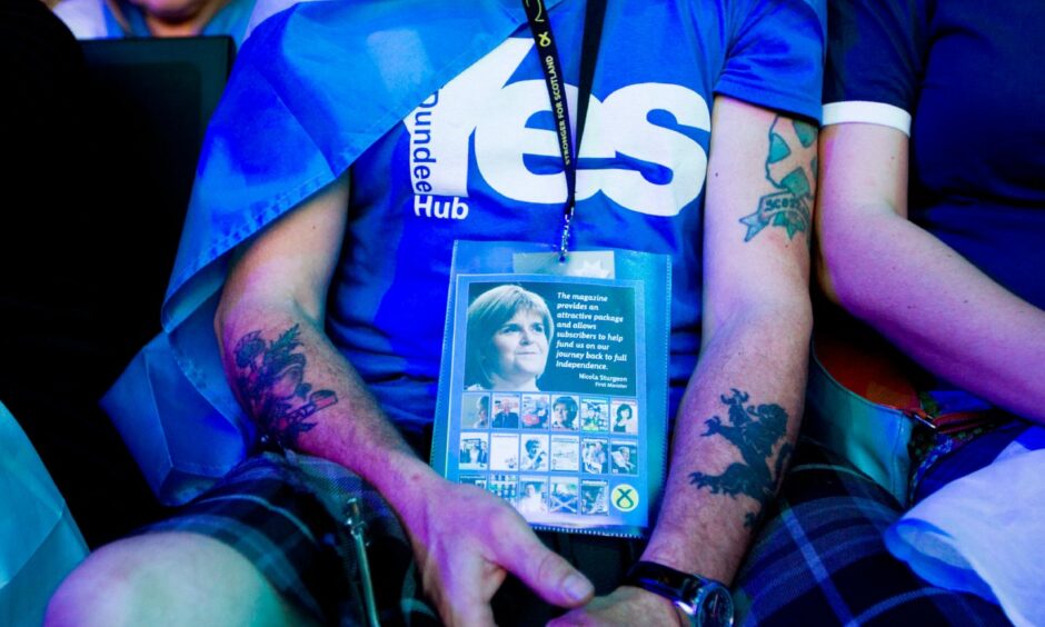 A Scottish Independence supporter wearing a 'Yes' T-shirt sitting at an SNP party conference 