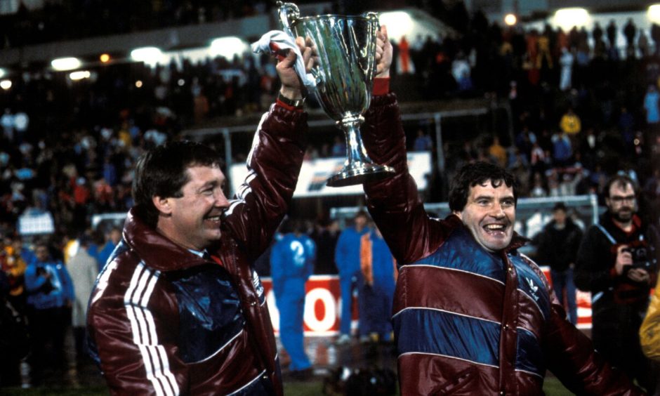Alex Ferguson and assistant Archie Knox celebrate winning the European Cup Winners' Cup trophy with Aberdeen in 1983.