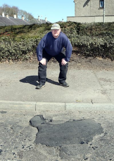 Nigel Bain beside the patched up pothole in Arbroath.