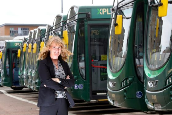 Christine McGlasson, managing director, standing in front of some Xplore Dundee buses