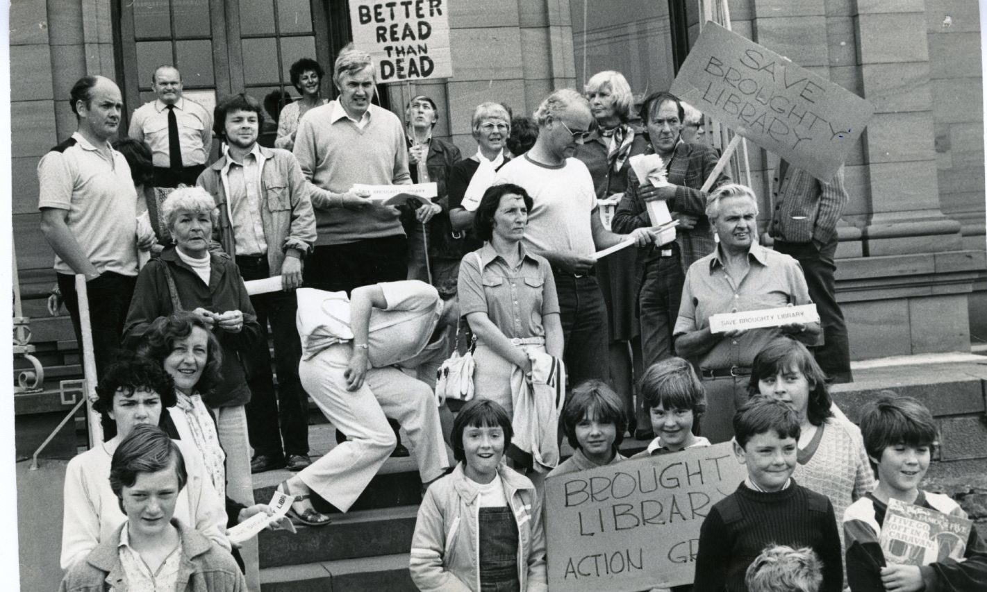 A group outside a library protesting closures