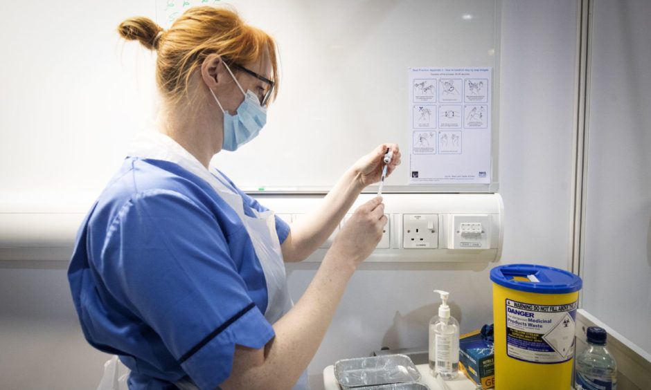 A nurse prepares to give a Covid vaccine. NHS Grampian is warning people should not think the jab gives them 'superpowers' ahead of pubs and restaurants reopening next week