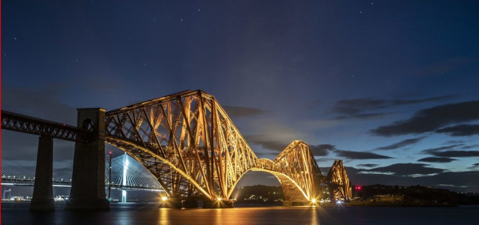 A striking image of the Forth Bridge bathed in a golden hue.
