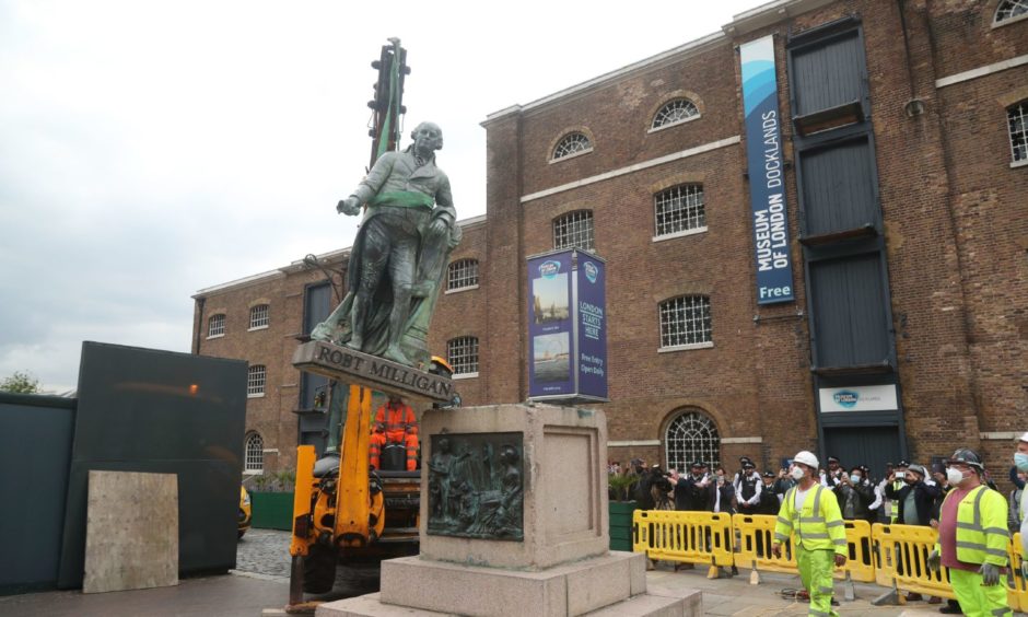 Workers prepare to take down a statue of slave owner Robert Milligan at West India Quay, east London.