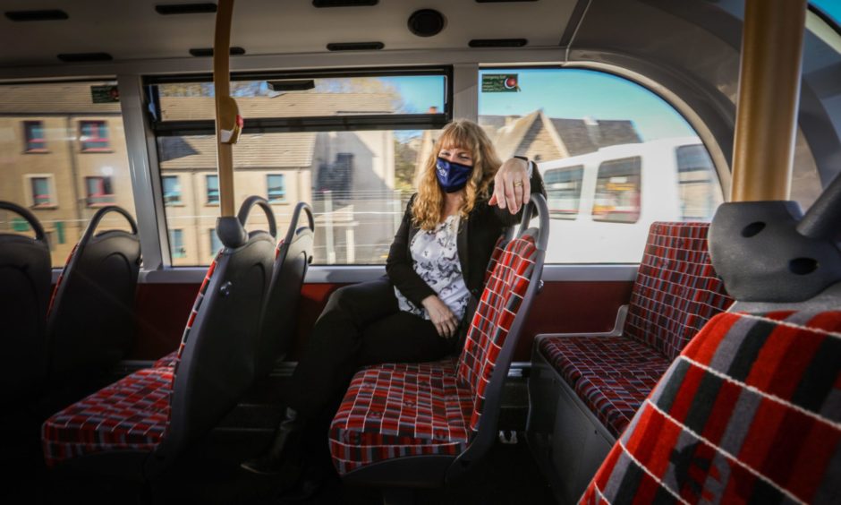 Christine McGlasson wearing a face covering on board an Xplore Dundee bus.