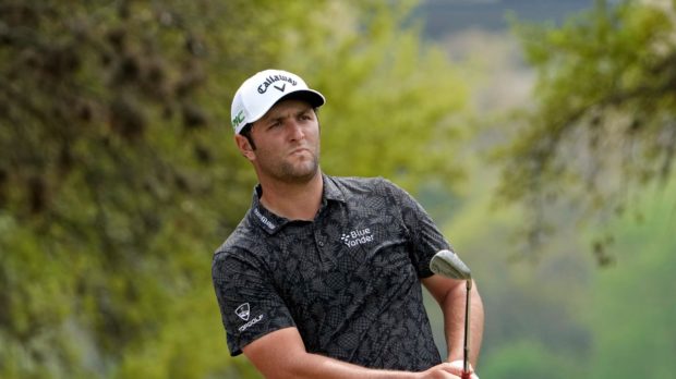 Golfer Jon Rahm looking on intently after playing a shot