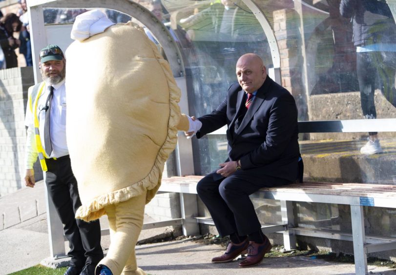 Arbroath manager Dick Campbell shakes hands with Baxter the Bridie.