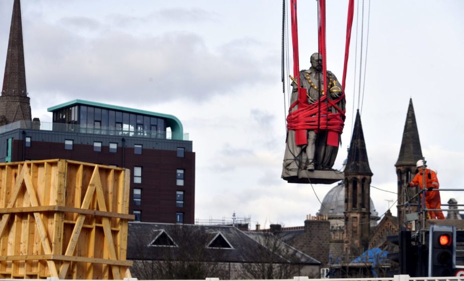 A large crane lifting the Edward VII statue in Aberdeen