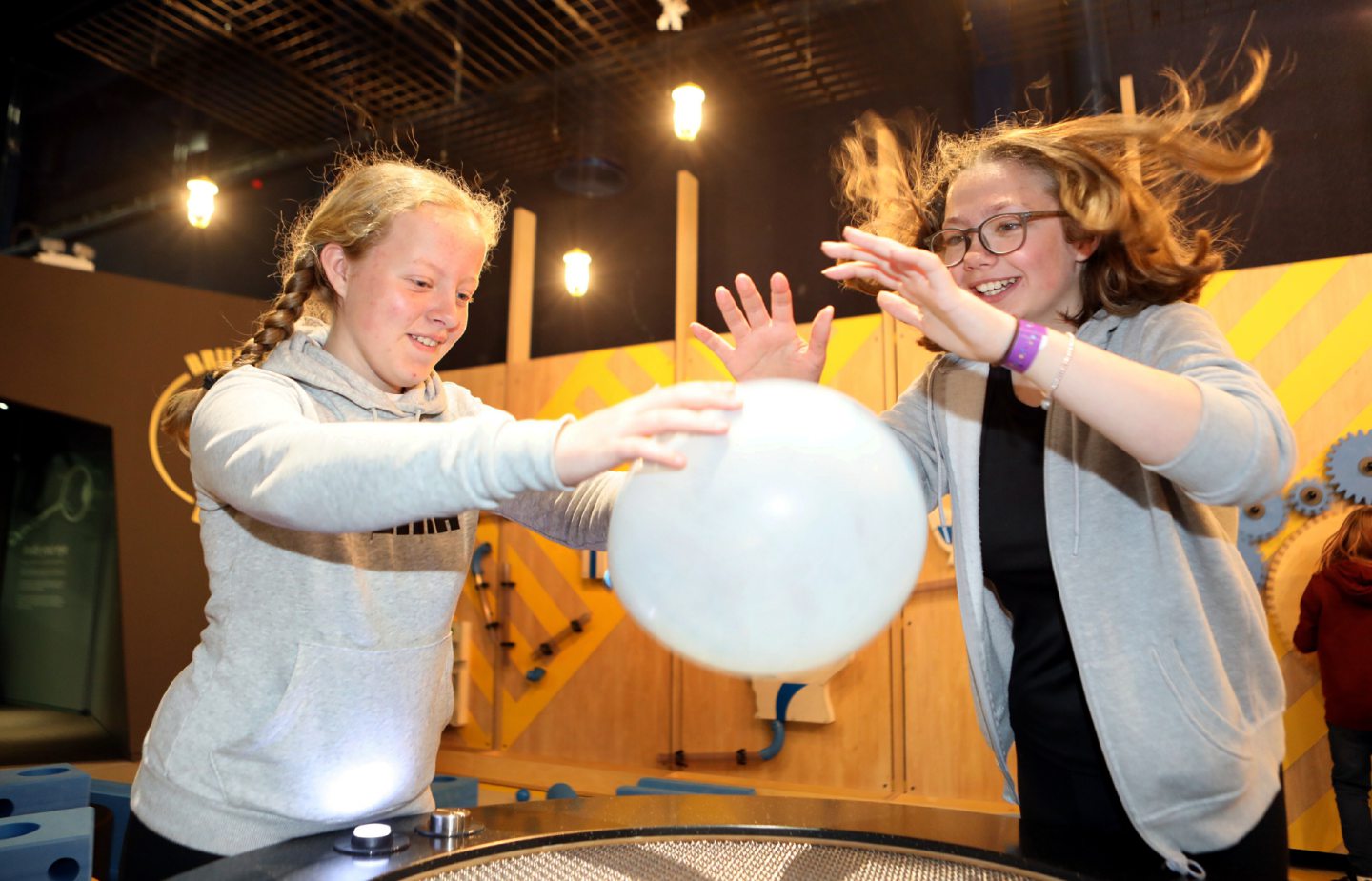 Flo Steadman and Ashlyne Johnstone play with a balloon on the air machine.