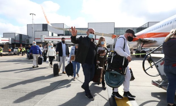 Passengers prepare to board an easyJet flight to Faro, Portugal, at Gatwick Airport in West Sussex.